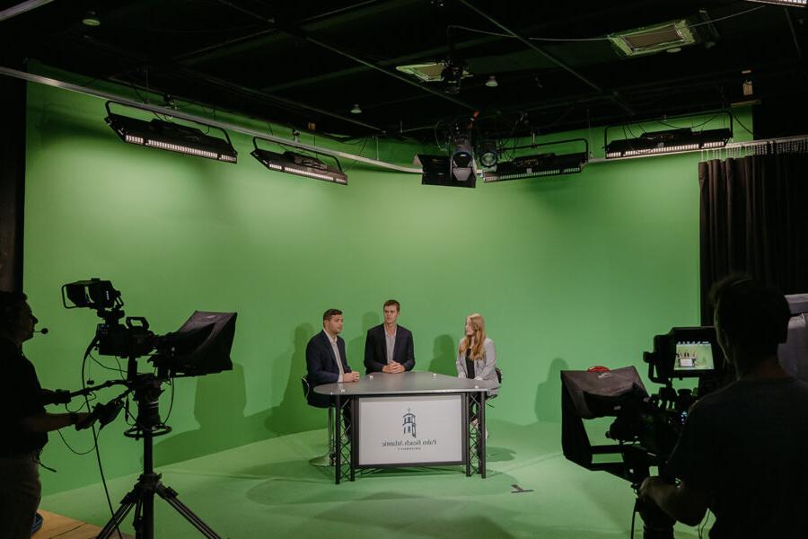 体育 broadcasting students present in front of a green screen.